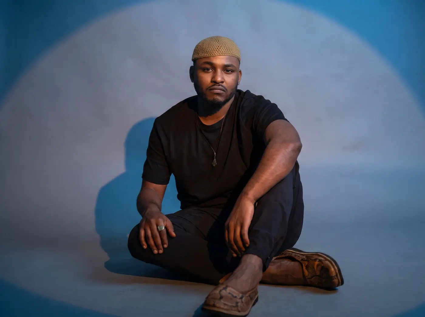 Mohamed Al Tayeb zittend in blauw licht